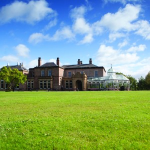 The exterior of Preston Park Museum with lawn in the front and a large conservatory on the side